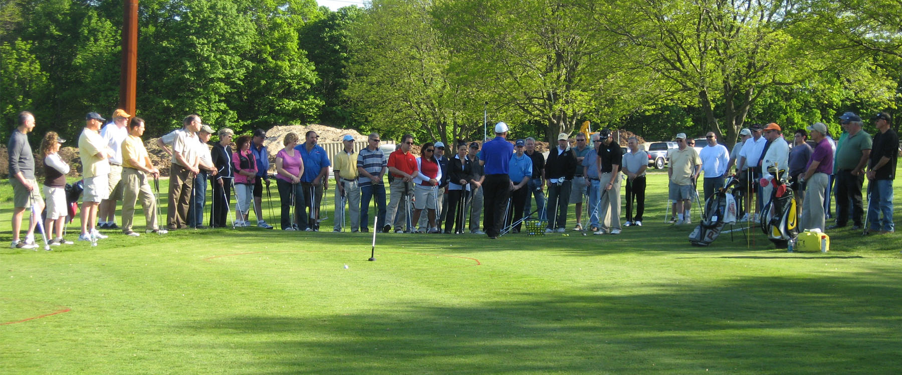 Players and spectators standing around golf player